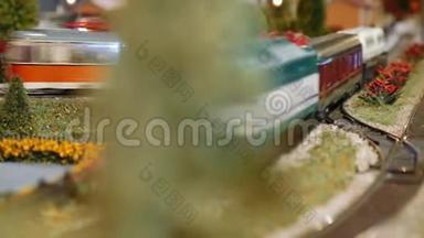 在迪奥拉马的一棵树后面经过的火车模型